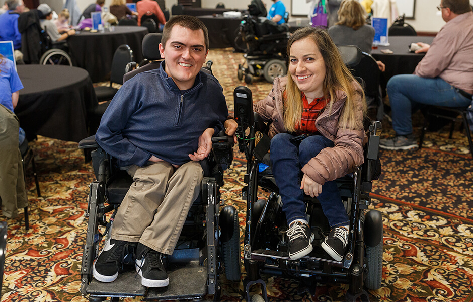 man and woman in wheelchairs at social event