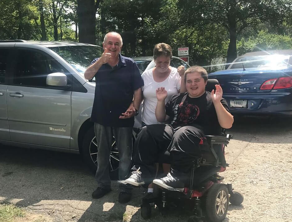 boy and family in front of van