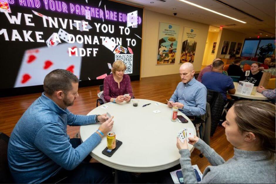 Card players sit around a table